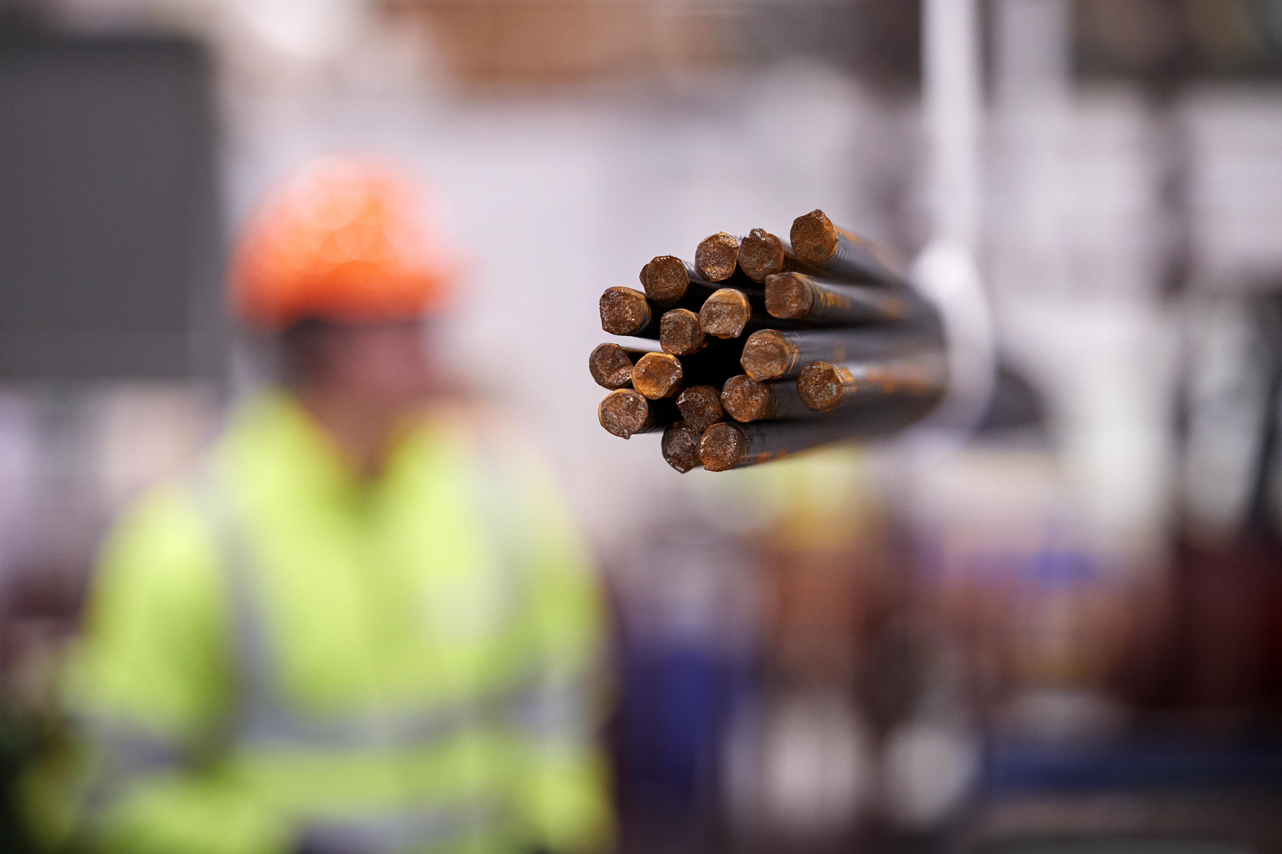 Man i keps som står vid en maskin